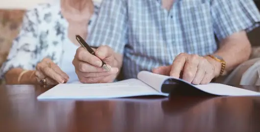 Image of a elderly couple filling out legal documents. | Keystone Law