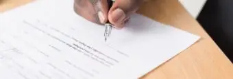 Image of a person filling out a form. | Keystone Law