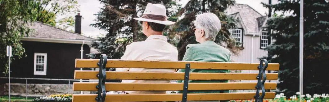 two people sitting on a park bench