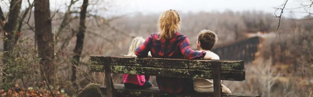 woman sitting on a park bench with a child