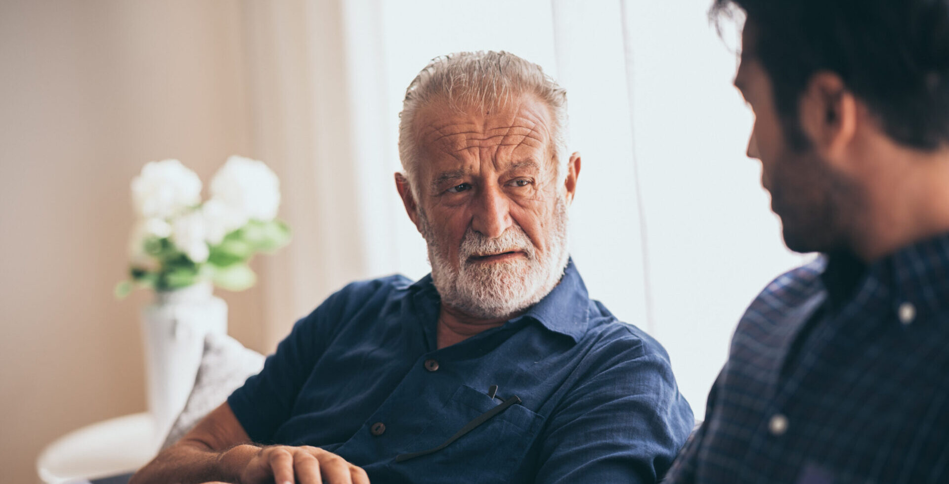 Elderly father looking at son confused