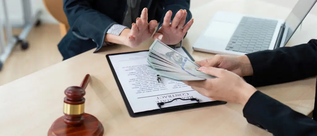 Lawyer Accepting Bribe Money for Corruption in Office Setting with Contract and Gavel on Desk