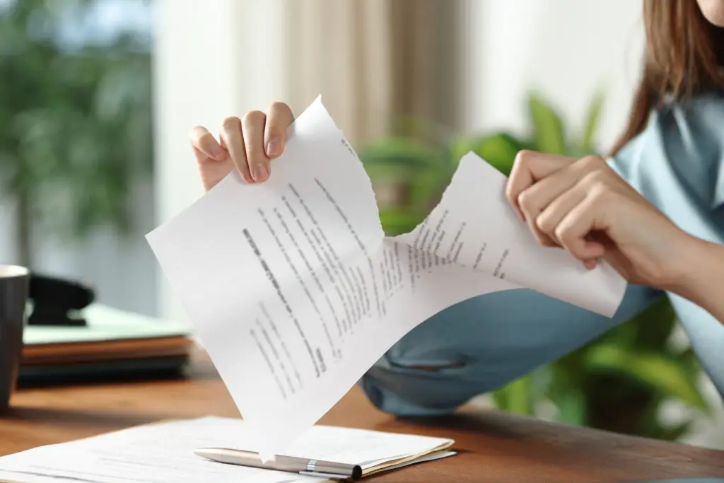 Businesswoman hands breaking contract at office