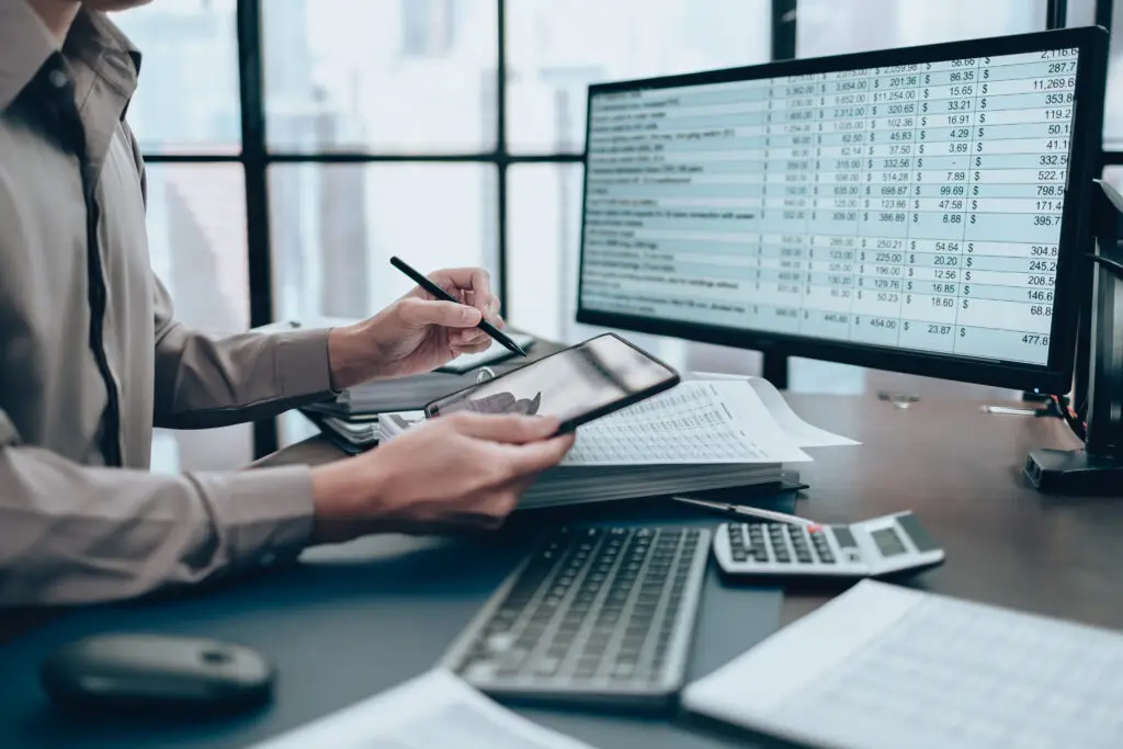 Investors working on desk office and use tablet to  check tracki