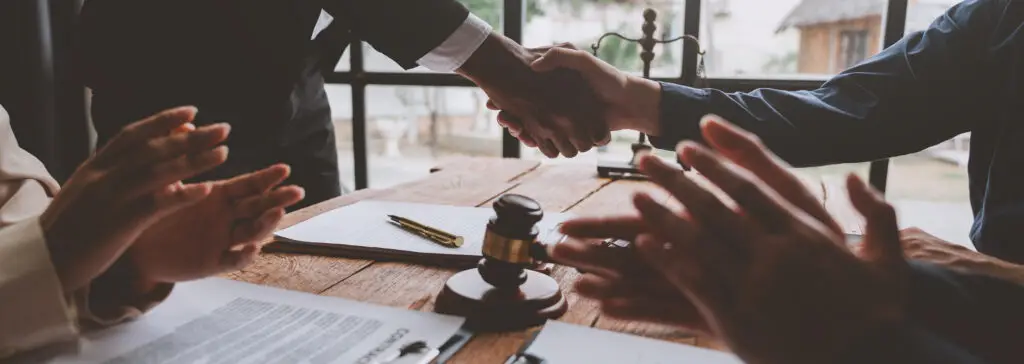 Lawyer shaking hands with businessman, investor in financial agreement, partner congratulating success or lawyer discussing contract agreement. Handshake concept. Agreement